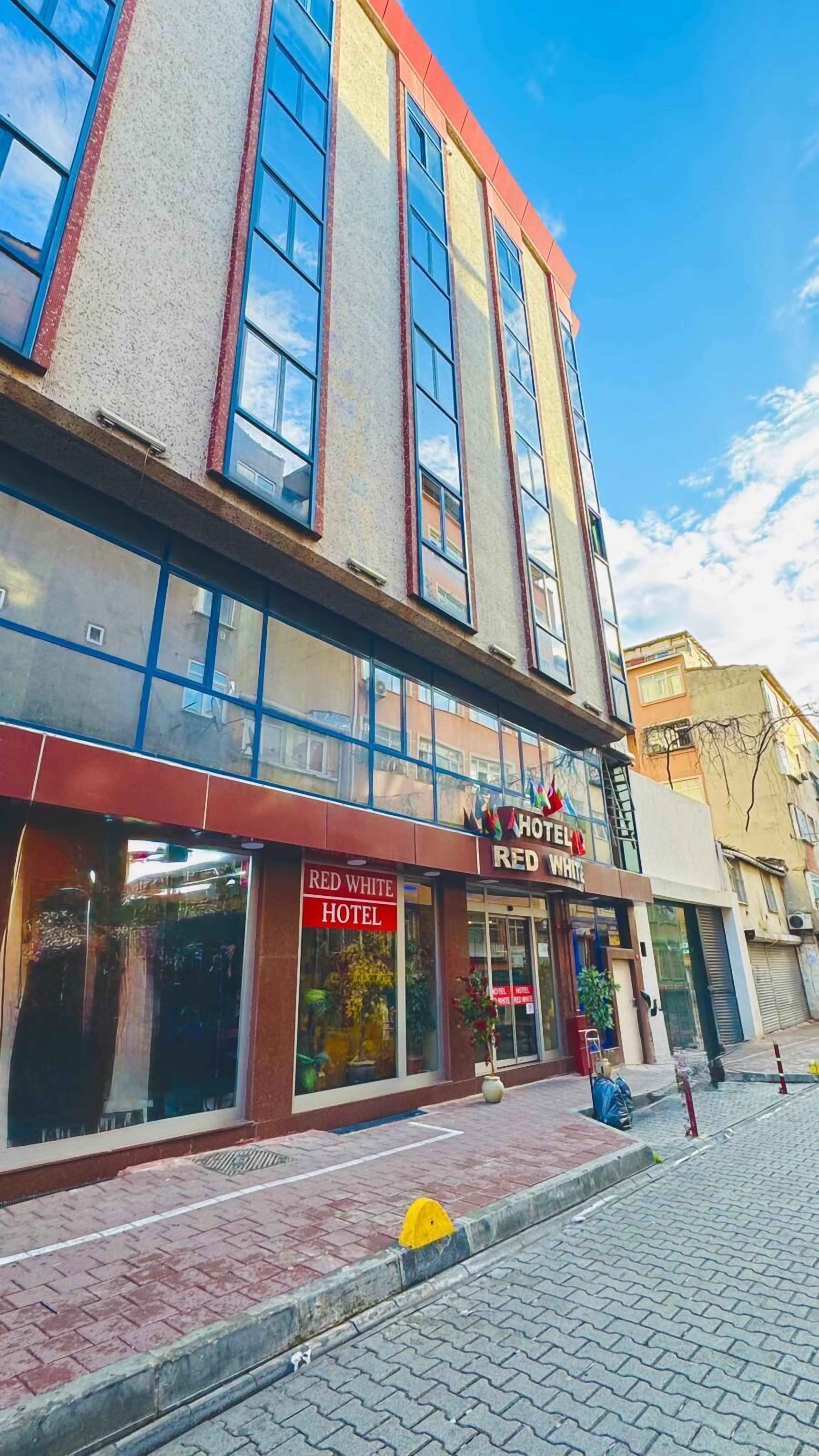 A hotel with a red facade and large windows.