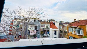 Vista de una zona residencial con edificios de varios pisos, algunos con balcones, y un cielo despejado con nubes.
