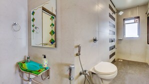 Een badkamer met toilet, wastafel, douche en een spiegel met decoratieve details.