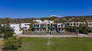 A modern building with a pool area, surrounded by greenery and hills in the background. - Holiday home in Kiotari with a barbecue (Kiotari)
