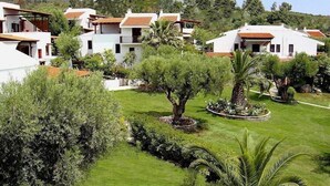 A residential area with white houses, green lawns, and trees.