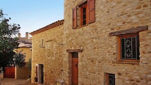 A stone building with a wooden door and window shutters. - Scenic Village Home with Lake Panorama (Sainte-Croix-du-Verdon)