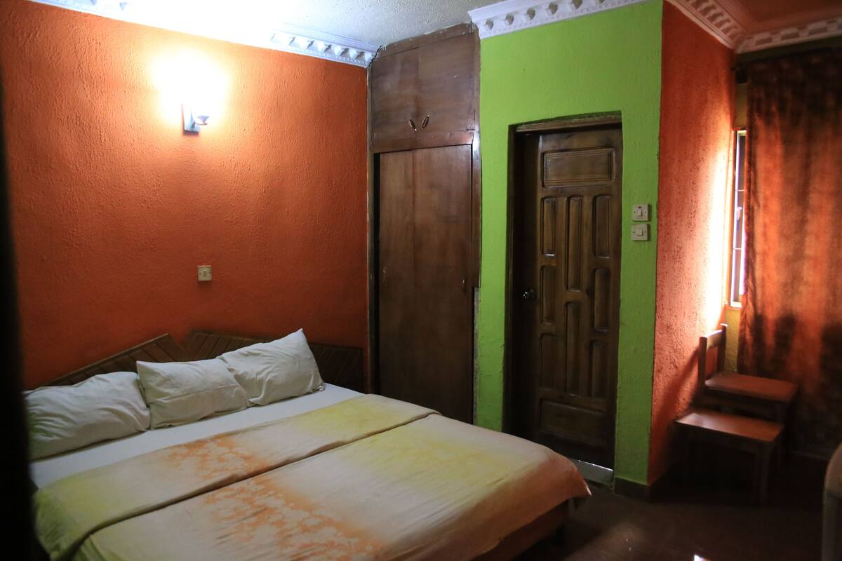 Ein Zimmer mit einem Bett, einem Kleiderschrank und einer grünen Wand.