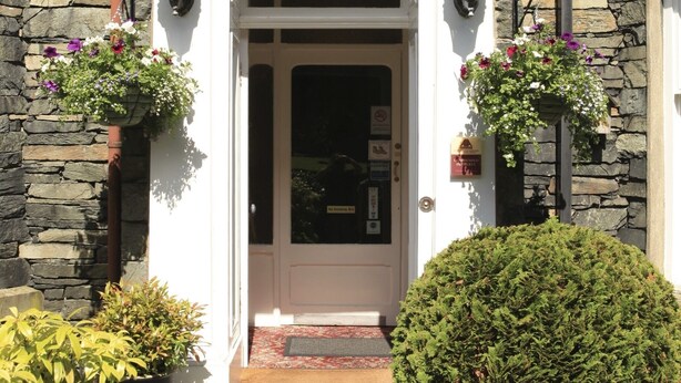A building entrance with a sign reading "STRATHMORE" and a stone facade. - Strathmore Guesthouse - Adults Only (Keswick)