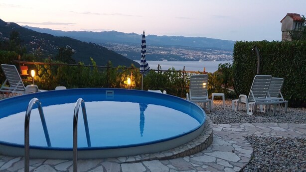 A swimming pool with a view of a city and mountains in the background.
