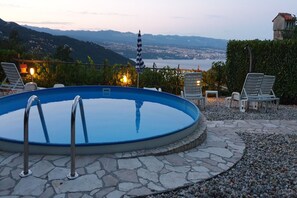 A swimming pool with a view of a city and mountains in the background. - Stone House in Dobrec with Sea View & Pool (Lovran)