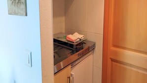 Una cocina con estufa, una toalla sobre la encimera y una puerta a la derecha.