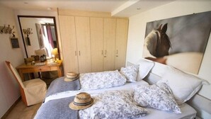 Un dormitorio con cama, escritorio y armario.