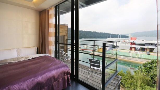 Un dormitorio con un amplio ventanal con vistas a un río y un puente.