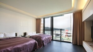 Habitación de hotel moderna con dos camas, un ventanal con vistas y un televisor de pantalla plana.