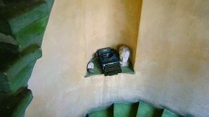 A staircase with a green railing and a beige wall. - Teytz Apartments (Prague)