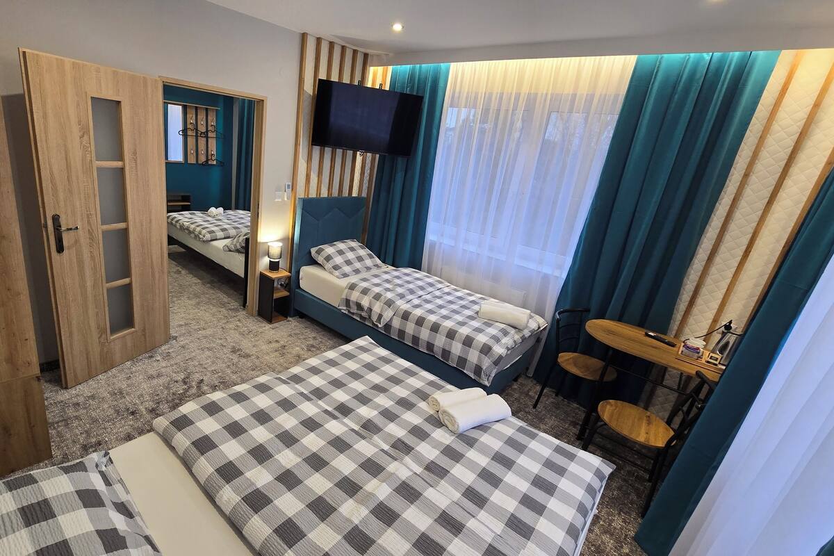 Une chambre d’hôtel avec deux lits, une télévision, une petite table et une chaise.