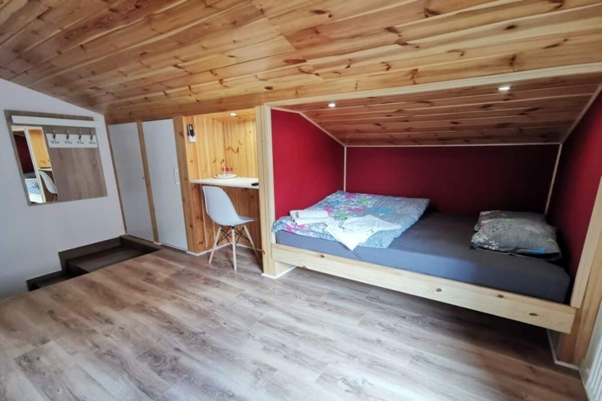 Une petite pièce comprenant un lit, un bureau et une chaise.