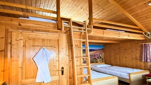 A wooden cabin with two beds, a ladder, and a door with a towel hanging. - Chalet in Gaal by Ski Slopes & Alpine Park (Gaal im Murtal)