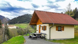 A small, single-story building with a red-tiled roof and a wooden porch. - Chalet in Gaal by Ski Slopes & Alpine Park (Gaal im Murtal)