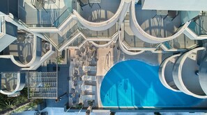 A modern building with a central swimming pool, outdoor seating, and a glass balustrade. - Hotel Mediterranean Resort (Katerini)