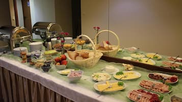 A buffet with various food items and utensils.
