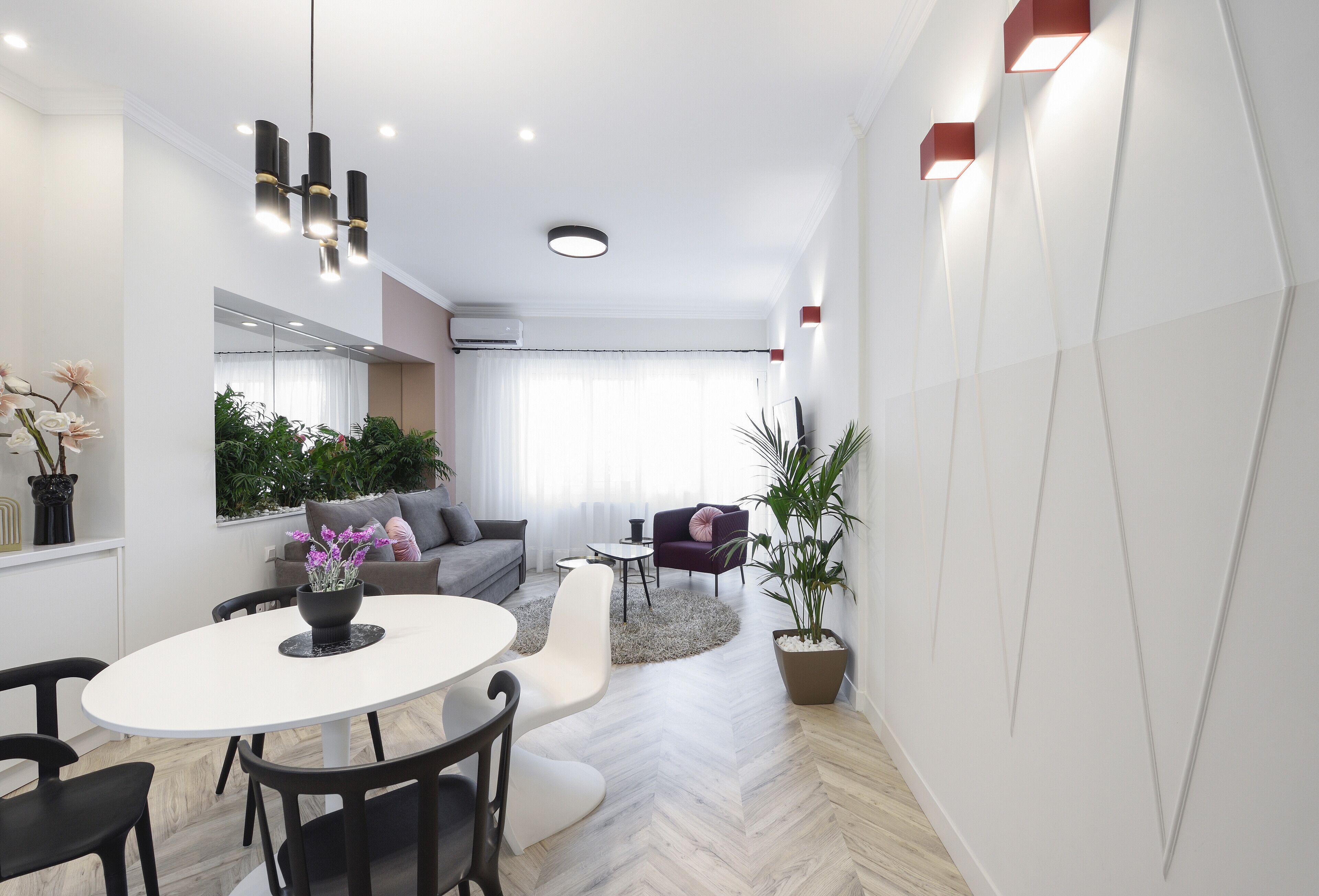 A modern living room with a dining area, a sofa set, a coffee table, and a potted plant.