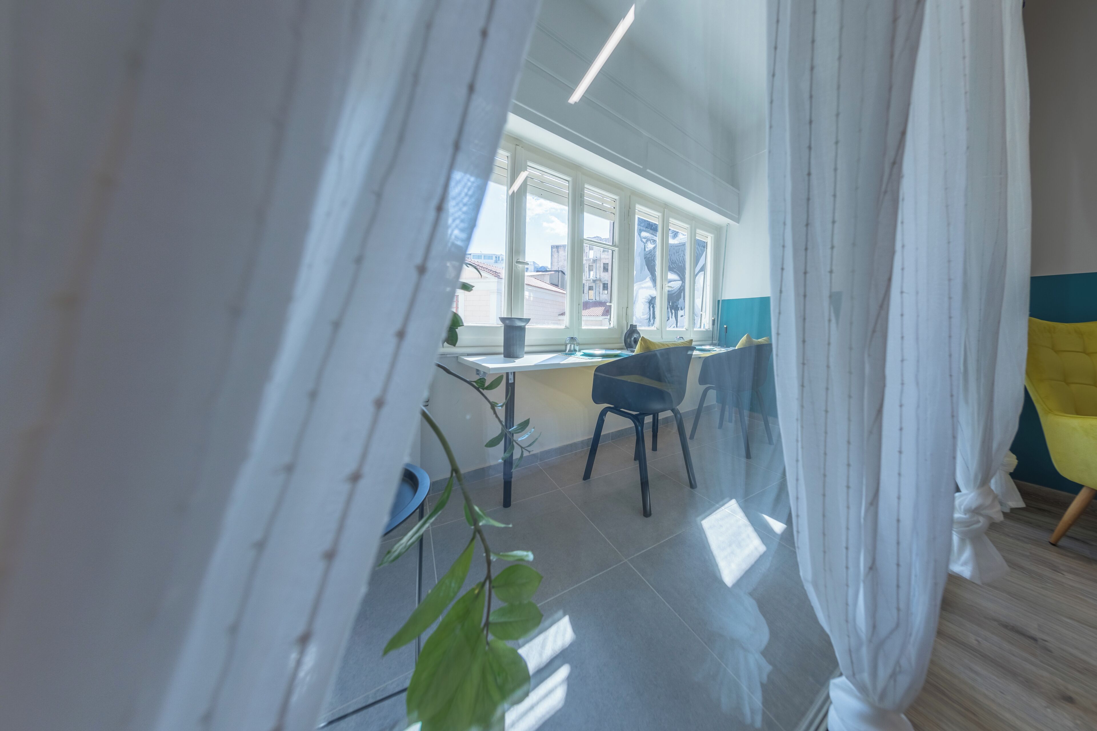 A modern room with a large window, a chair, and a table.