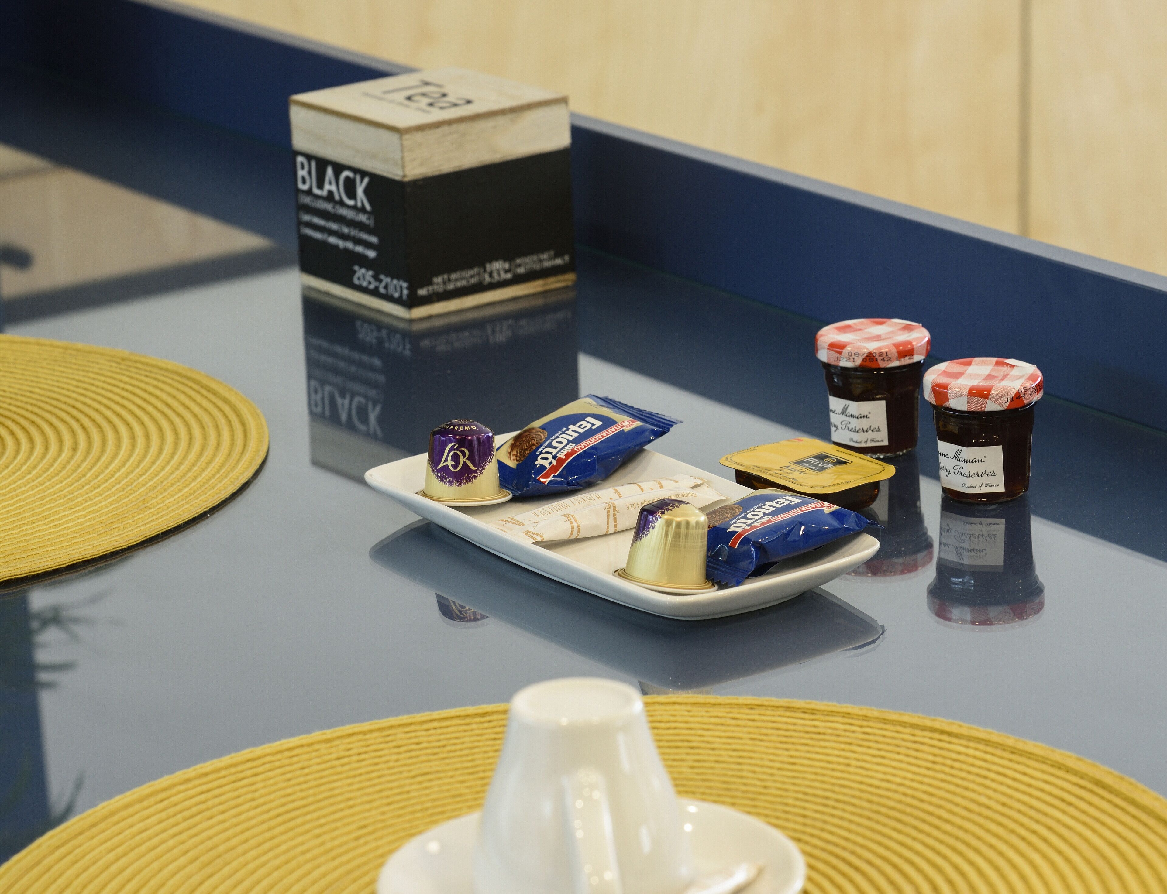 Een dienblad met chocolade en confituur op een tafel met een blauwe rand.