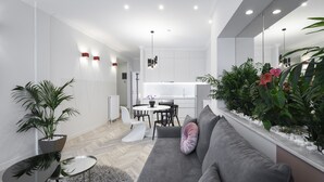 Un espace de vie moderne avec un canapé gris, une petite table ronde et une plante en pot.