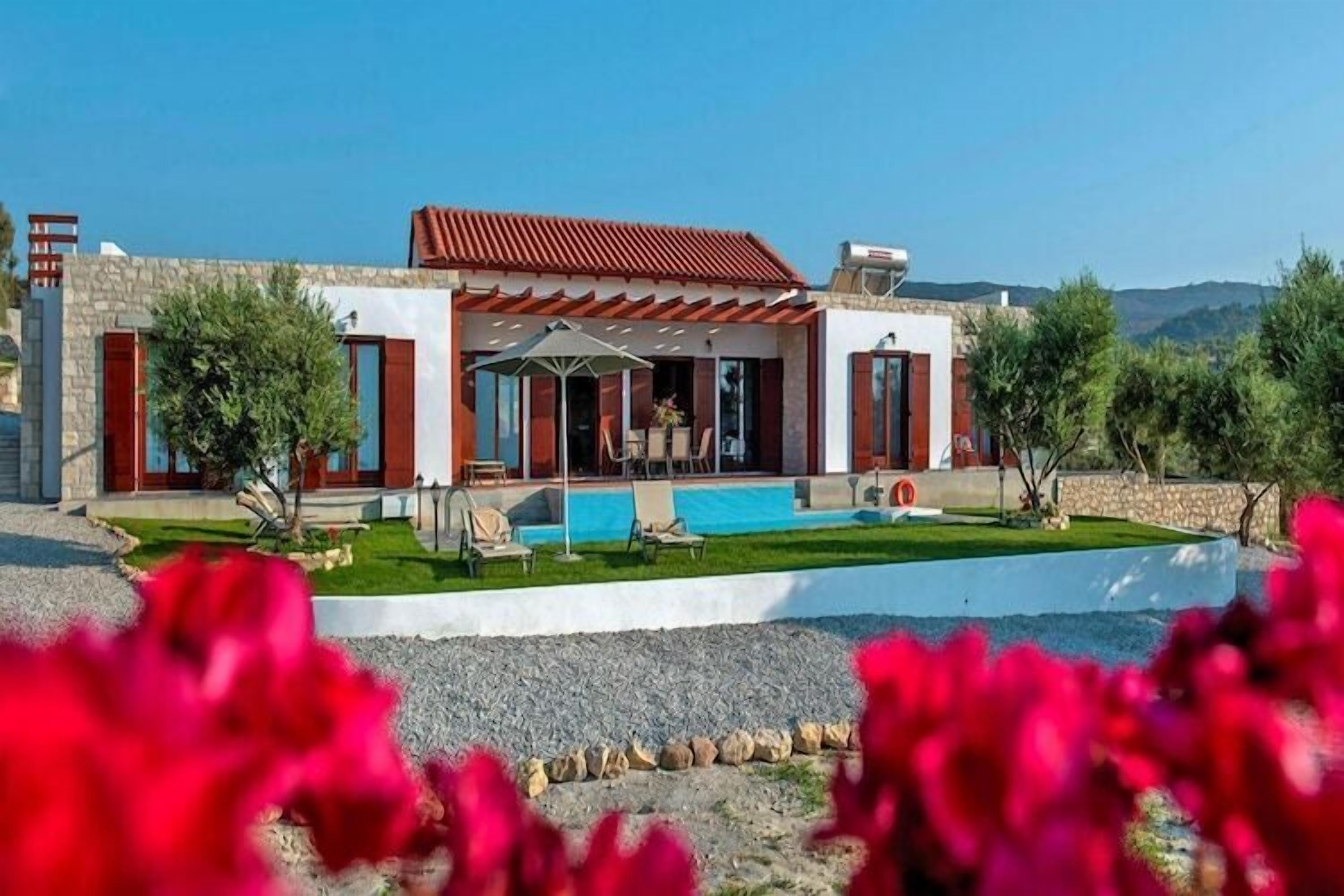 Uma casa moderna com piscina, área de estar externa e fachada de pedra.