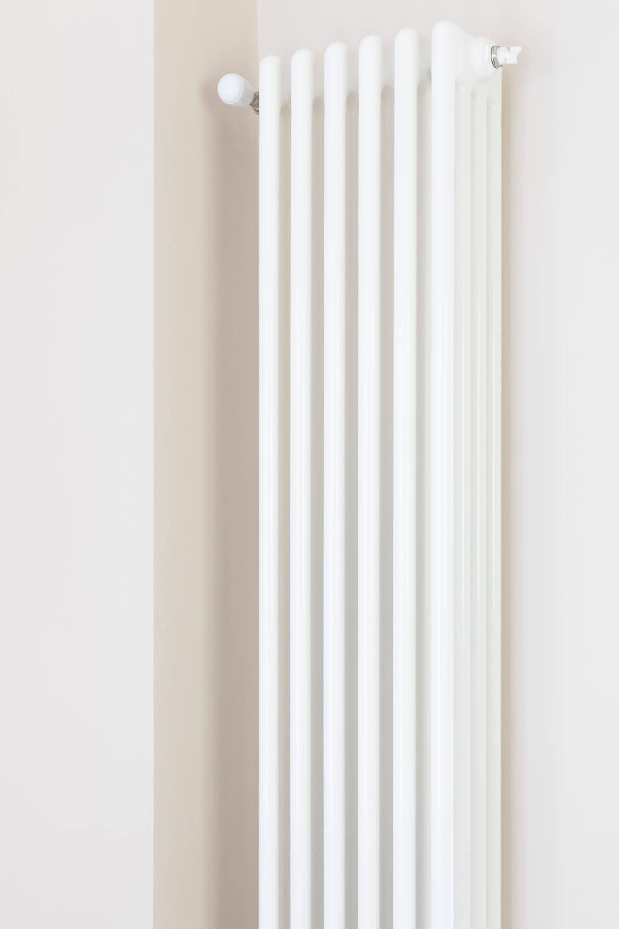 En hvid radiator foran en lys væg.