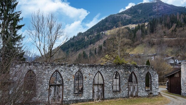 A stone building with arched windows and a wooden door, surrounded by a rural landscape with mountains in the background. - Apartment in Fügen near Spieljochbahn (Fügen)