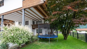 A residential property with a covered patio, a trampoline, and a well-maintained lawn. - Apartment in Fügen near Spieljochbahn (Fügen)