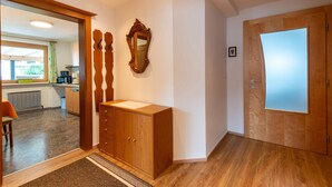 A modern kitchen with wooden cabinets, a built-in oven, and a window overlooking the garden. - Apartment in Fügen near Spieljochbahn (Fügen)