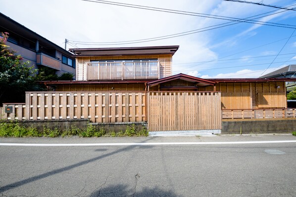 A two-story building with a wooden fence and a red roof. - Fujisan-Kingyo (Fujikawaguchiko)