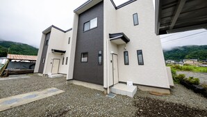 Un bâtiment moderne à deux étages, doté d’un toit plat et d’une allée gravillonnée.
