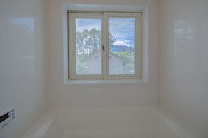 A room with a large window, white walls, and a visible outdoor view. - Mt. View A (Fujikawaguchiko)