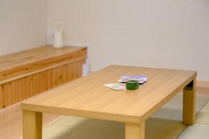 Una pequeña mesa de madera con algunos objetos encima, incluyendo un elemento verde y unos documentos.
