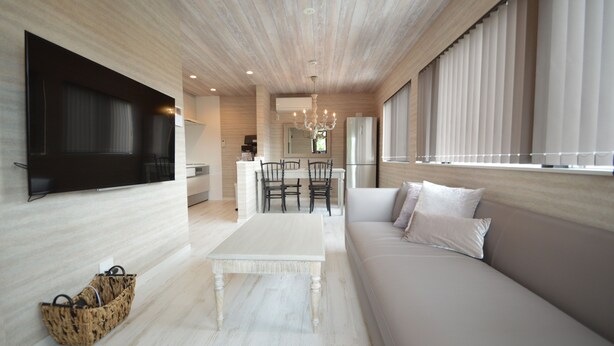 A modern living room with a sofa, a coffee table, and a TV mounted on the wall. - enico.Mt.Fuji peace (Fujikawaguchiko)