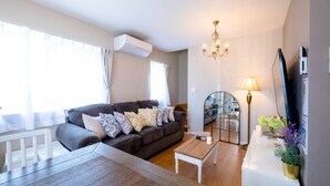 Een woonkamer met een bank, salontafel en een televisie.