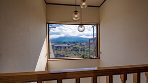 Une pièce dotée d’une grande fenêtre donnant sur un quartier résidentiel et des montagnes.