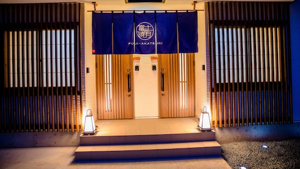 A building entrance with a blue banner displaying the name "FUJI-AKATSUKI". - Mt. Fuji Akatsuki Kuu (Fujikawaguchiko)