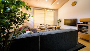A modern living room with a sofa, dining table, and a TV. - Mt. Fuji Akatsuki Kuu (Fujikawaguchiko)