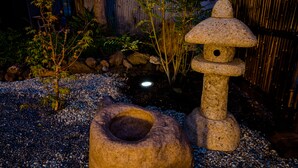 A stone lantern and a stone well in a garden with pebbles and plants. - Mt. Fuji Akatsuki Kuu (Fujikawaguchiko)