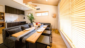 A modern kitchen with dark cabinets, a wooden countertop, and a built-in oven. - Mt. Fuji Akatsuki Kuu (Fujikawaguchiko)