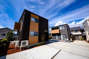 A modern two-story residential building with a flat roof, large windows, and a small patio area with outdoor furniture. - Oriya Mt.Fuji -Enishi- (Fujikawaguchiko)