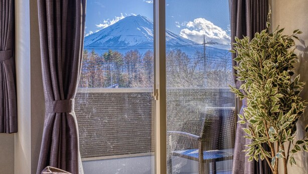 A room with a large window offering a view of a mountain. - Oriya Mt.Fuji -Enishi- (Fujikawaguchiko)