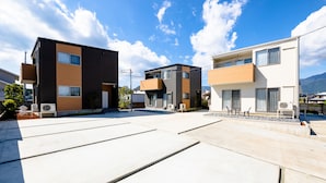 A residential area with modern multi-story buildings, outdoor seating, and air conditioning units. - Oriya Mt.Fuji -Nishiki- (Fujikawaguchiko)