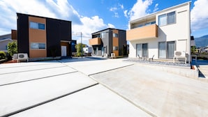 A modern residential area with contemporary buildings, a clear sky, and a flat rooftop.
