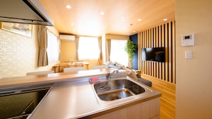 A modern kitchen with a stainless steel sink, wooden cabinets, and a built-in stove.