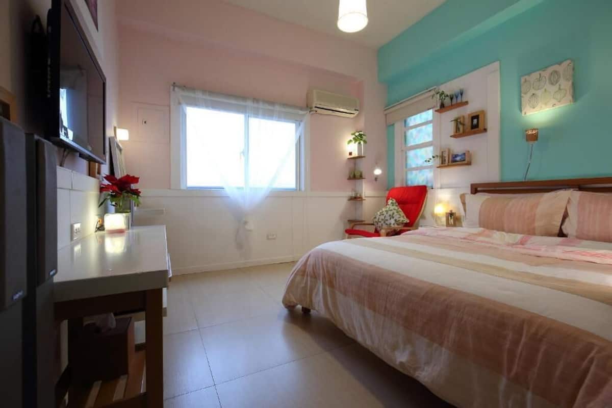 A bedroom with a bed, bedside table, and a TV.
