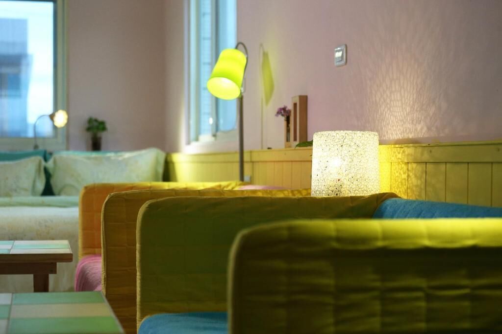 Une pièce confortable avec un lit, une chaise et une lampe.