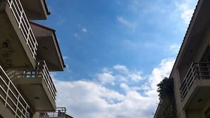 A multi-story residential building with balconies, a central pathway, and surrounding greenery. - Huxi B&B (Ji'an)