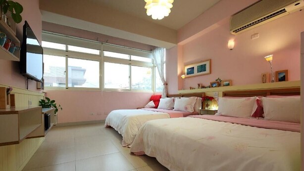 A hotel room with two beds, a television, a window with curtains, and a kitchenette area. - Huxi B&B (Ji'an)
